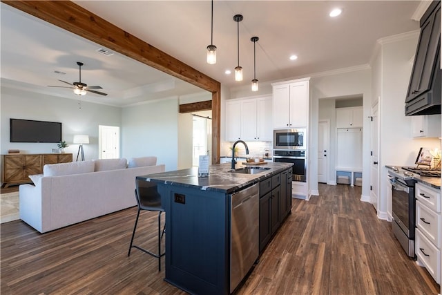 kitchen with white cabinetry, dark hardwood / wood-style flooring, stainless steel appliances, sink, and a center island with sink