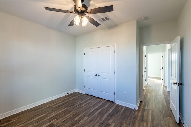 unfurnished bedroom featuring ceiling fan, a closet, and dark hardwood / wood-style flooring