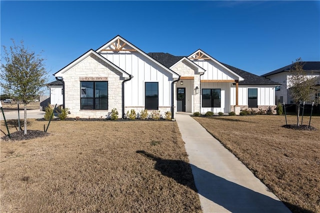 modern farmhouse style home featuring a front yard