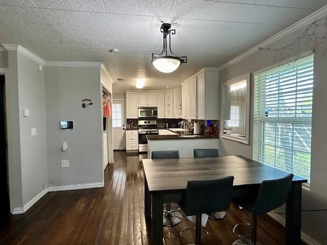 dining area with ornamental molding, dark hardwood / wood-style floors, and a healthy amount of sunlight