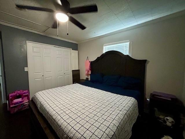 bedroom featuring ceiling fan, ornamental molding, and a closet