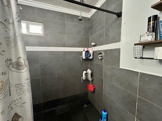 bathroom featuring walk in shower and ornamental molding