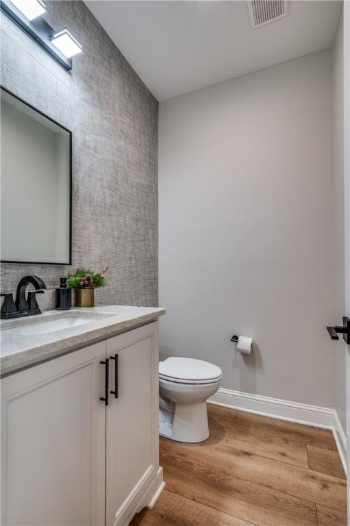 bathroom featuring vanity, toilet, and wood-type flooring