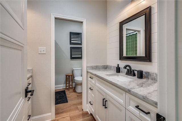 bathroom featuring hardwood / wood-style floors, vanity, and toilet