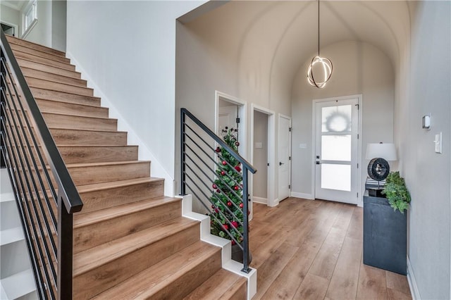 foyer featuring a towering ceiling and light hardwood / wood-style floors