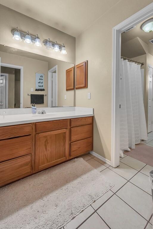 full bath featuring tile patterned flooring, vanity, and a shower with curtain