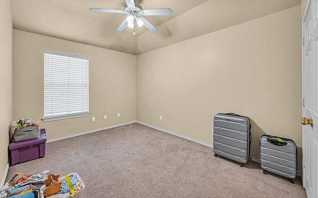 recreation room featuring a ceiling fan, carpet, vaulted ceiling, and baseboards