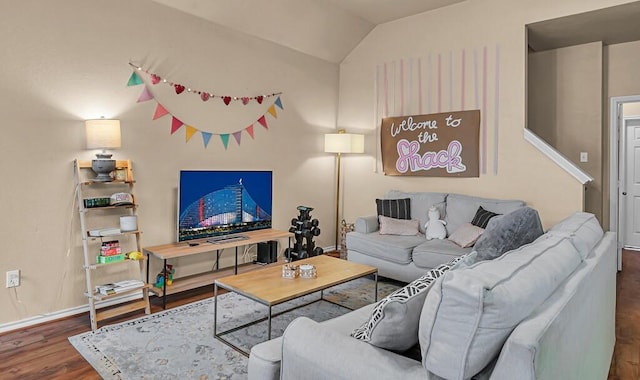 living area featuring baseboards, vaulted ceiling, and wood finished floors