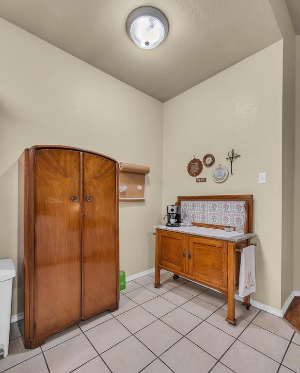 bathroom featuring toilet, tile patterned flooring, and baseboards