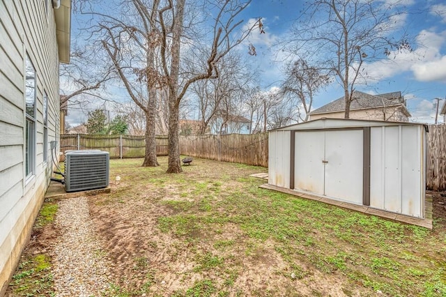 view of yard with a fenced backyard, an outdoor structure, a storage shed, and central AC unit