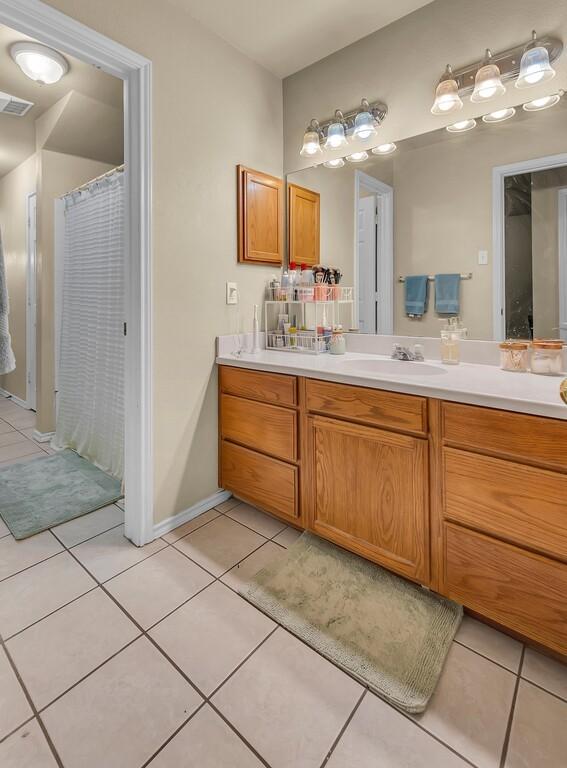 bathroom with a shower with curtain, tile patterned flooring, visible vents, and vanity