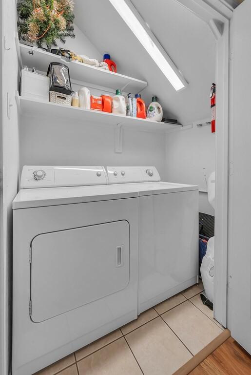 washroom featuring washer and dryer, laundry area, and light tile patterned floors