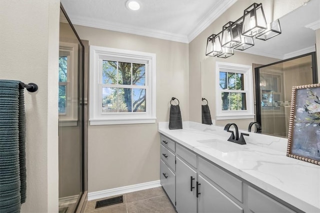 bathroom featuring tile patterned flooring, vanity, a shower with door, and crown molding