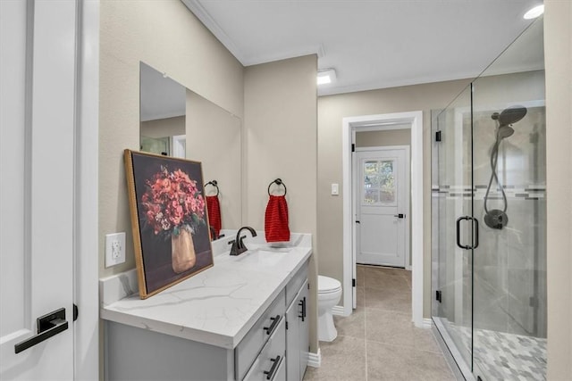 bathroom with tile patterned floors, a shower with door, vanity, and toilet