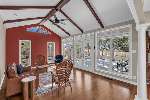 sunroom / solarium featuring french doors, vaulted ceiling with beams, ornate columns, and a healthy amount of sunlight