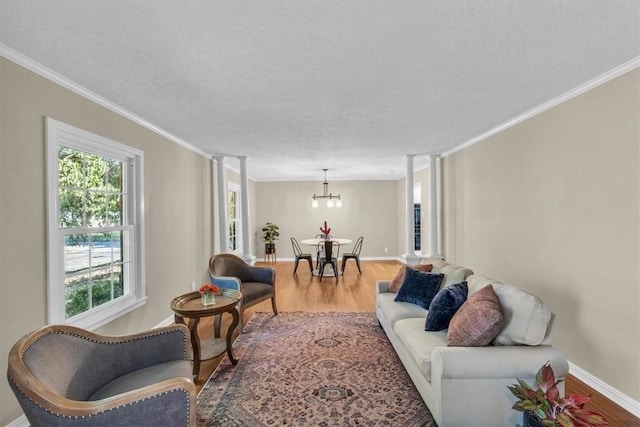 living room featuring wood-type flooring, a notable chandelier, and ornamental molding