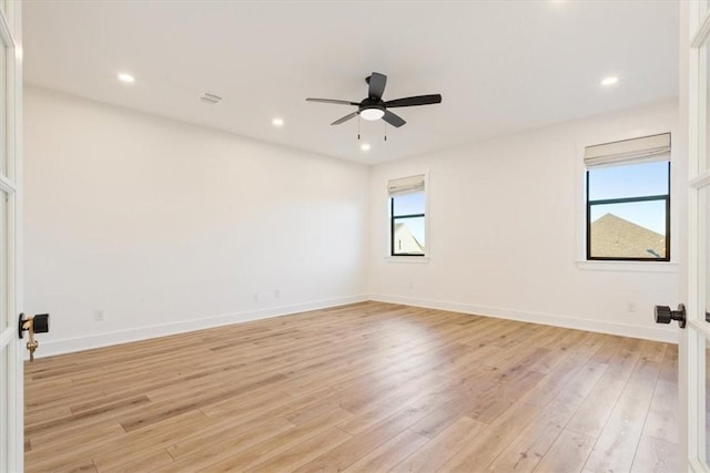 spare room with light hardwood / wood-style flooring, plenty of natural light, and ceiling fan