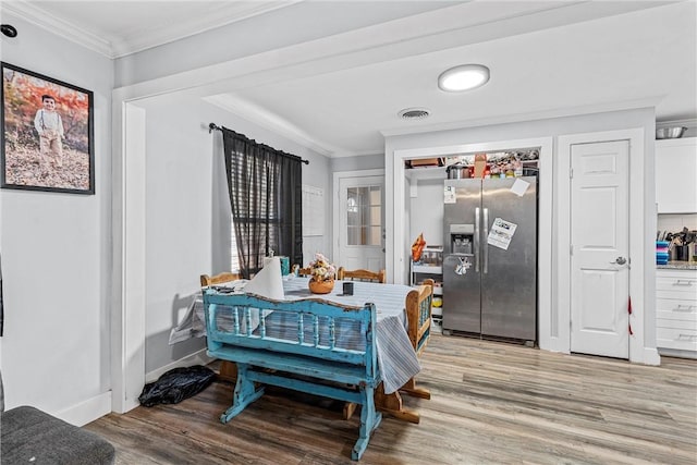 dining room with light hardwood / wood-style floors and ornamental molding