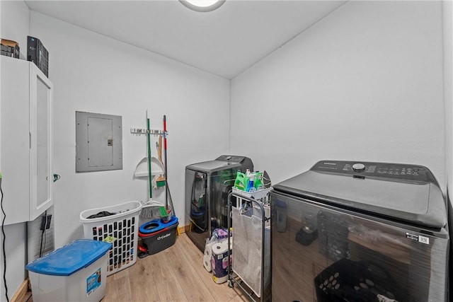 interior space with independent washer and dryer, electric panel, light hardwood / wood-style floors, and lofted ceiling