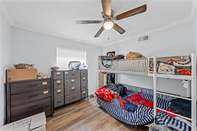 bedroom with ceiling fan, ornamental molding, and light wood-type flooring