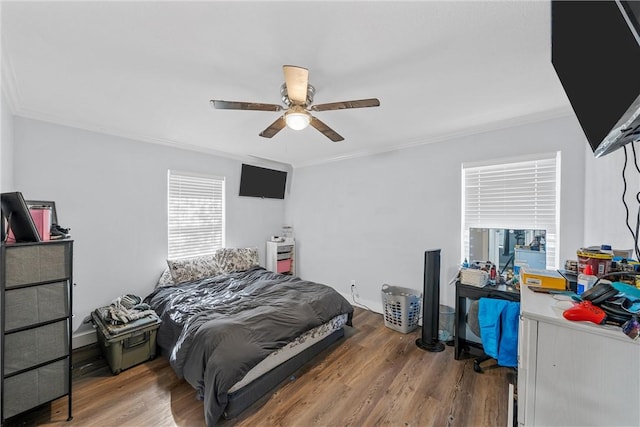 bedroom featuring ceiling fan, wood-type flooring, and ornamental molding