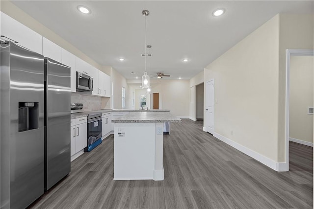 kitchen with ceiling fan, stainless steel appliances, pendant lighting, wood-type flooring, and white cabinets