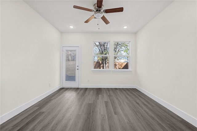 empty room with ceiling fan and dark hardwood / wood-style flooring