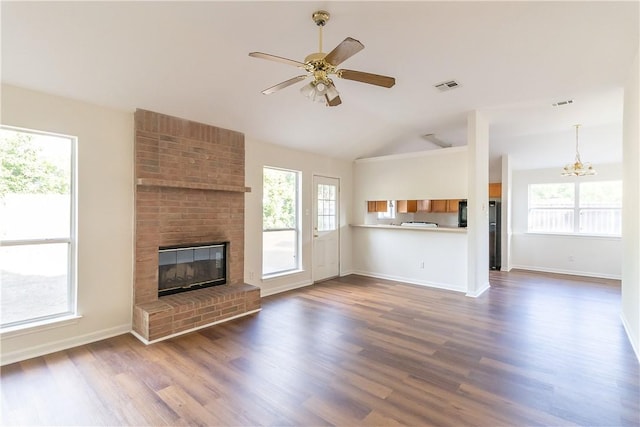 unfurnished living room featuring a wealth of natural light and dark hardwood / wood-style floors