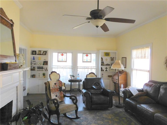 living room featuring a fireplace, ceiling fan, and crown molding