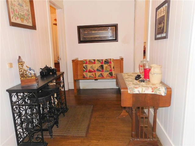 hallway featuring dark hardwood / wood-style flooring and wooden walls