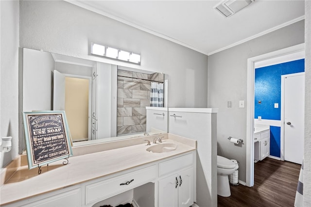 bathroom with vanity, a shower with curtain, toilet, ornamental molding, and wood-type flooring