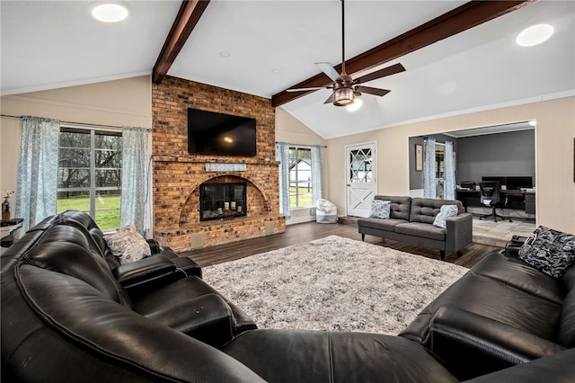 living room with a brick fireplace, hardwood / wood-style flooring, vaulted ceiling with beams, ceiling fan, and ornamental molding