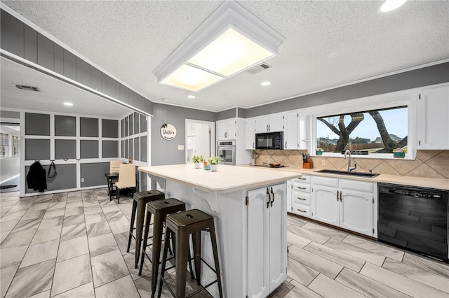 kitchen with a center island, sink, tasteful backsplash, white cabinets, and black appliances