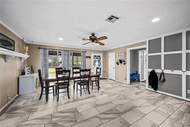 dining room featuring ceiling fan, crown molding, and a textured ceiling