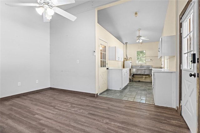 interior space with white cabinets, sink, vaulted ceiling, ceiling fan, and light hardwood / wood-style floors