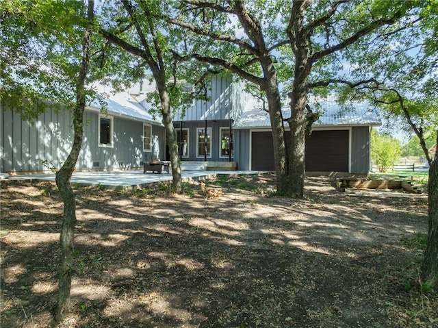 rear view of house featuring a patio and a garage