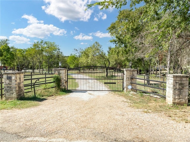 view of gate with a rural view