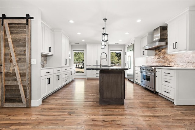 kitchen featuring white cabinetry, high quality appliances, wall chimney exhaust hood, and wood-type flooring