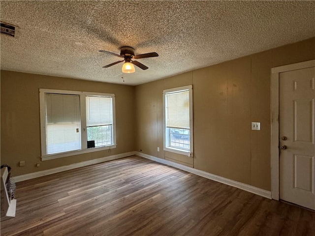 empty room featuring ceiling fan, a textured ceiling, and hardwood / wood-style flooring