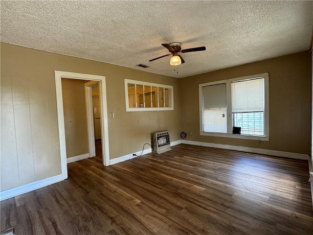 unfurnished room with heating unit, ceiling fan, dark hardwood / wood-style floors, and a textured ceiling