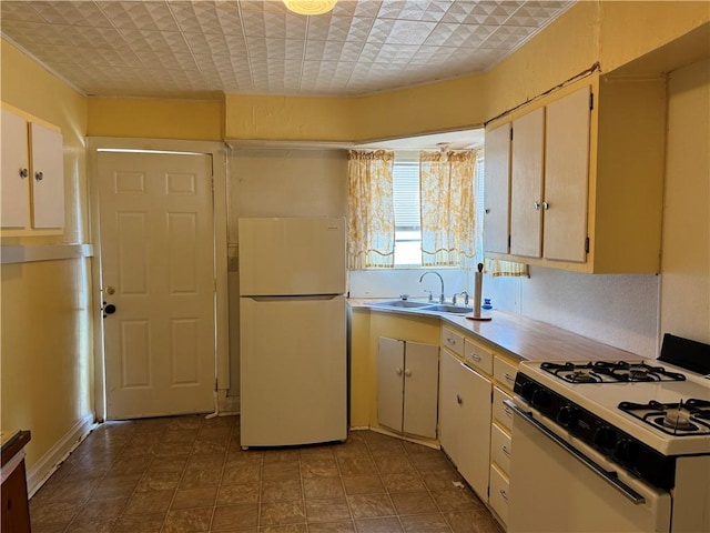 kitchen with sink, white appliances, and cream cabinetry