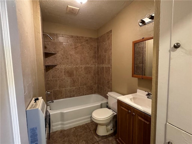 full bathroom featuring toilet, vanity, tile patterned floors, tiled shower / bath combo, and a textured ceiling