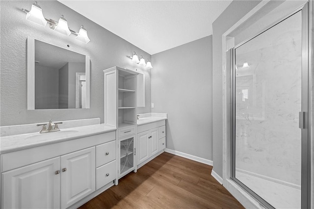 bathroom featuring vanity, an enclosed shower, wood-type flooring, and a textured ceiling