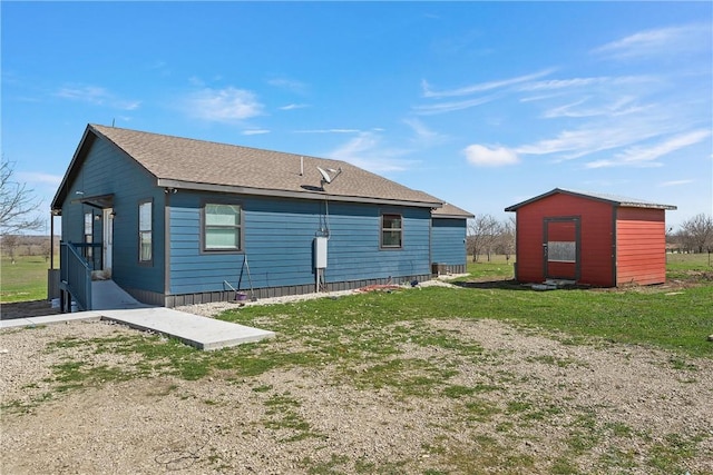 rear view of property featuring a shed