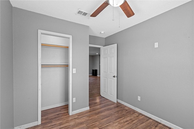 unfurnished bedroom with dark hardwood / wood-style flooring, ceiling fan, and a closet