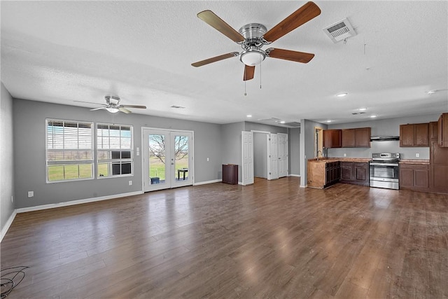 unfurnished living room with a textured ceiling, ceiling fan, sink, and dark wood-type flooring