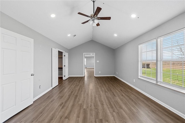 unfurnished living room featuring ceiling fan, dark wood-type flooring, and vaulted ceiling