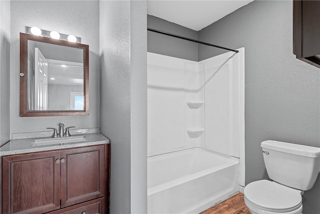 full bathroom with wood-type flooring, vanity, shower / bath combination, and toilet