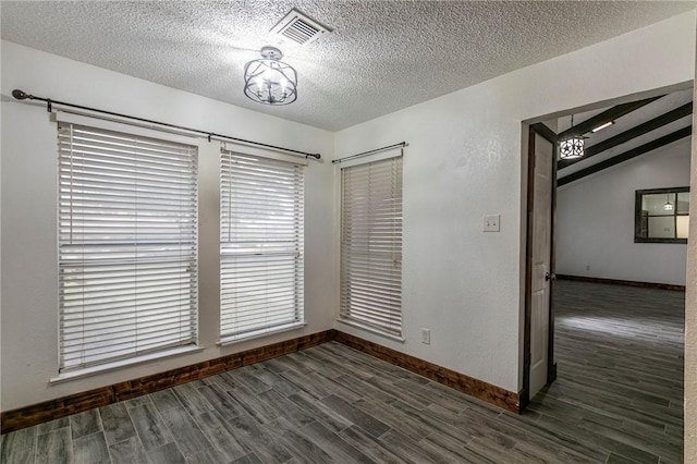 unfurnished room featuring vaulted ceiling, dark hardwood / wood-style floors, and a textured ceiling