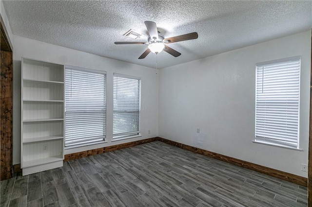 spare room with ceiling fan, dark hardwood / wood-style floors, and a textured ceiling